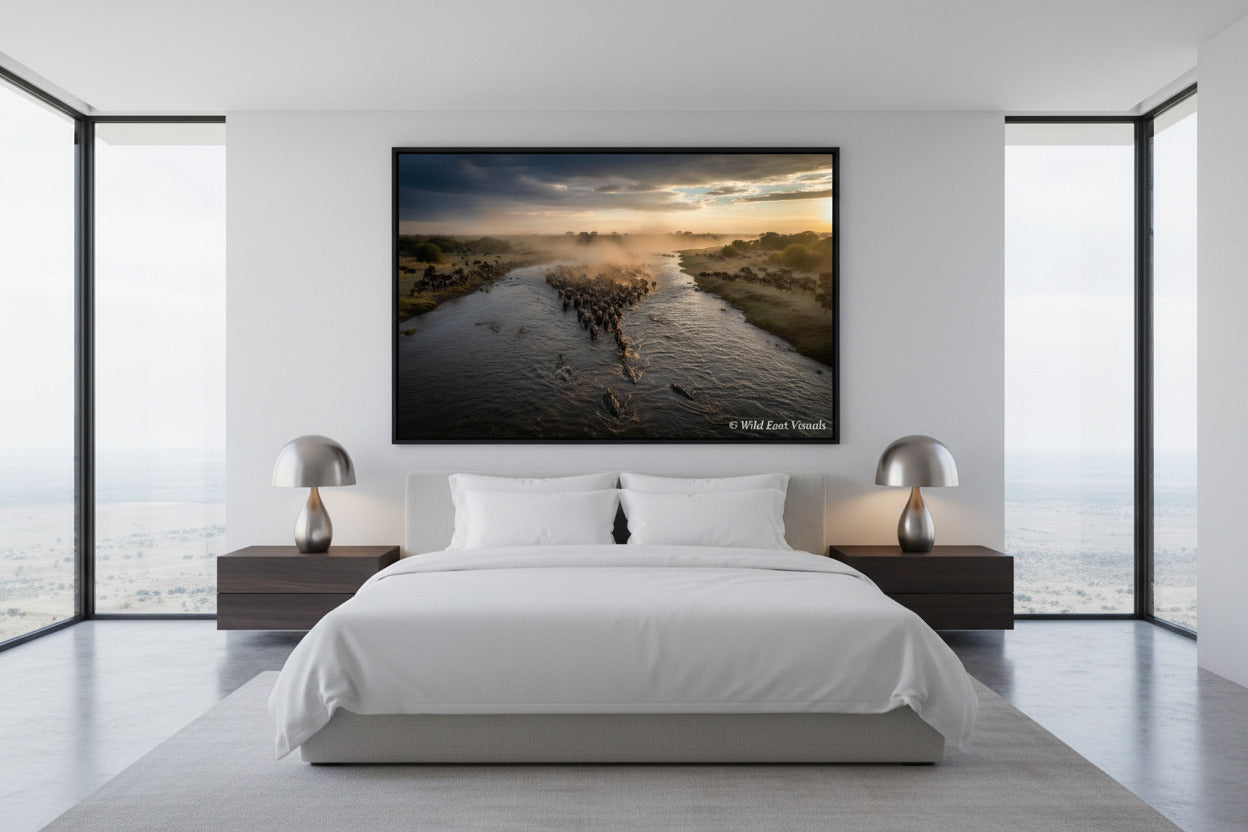 The Crossing — Dust & Thunder fine art giclée print displayed above a king bed in a modern luxury bedroom — Great Wildebeest Migration wildlife wall art — Wild East Visuals