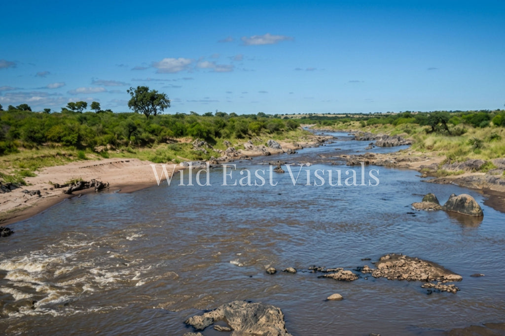 Mara River flowing quietly between rocky banks and lush green savannah, Maasai Mara, Kenya — Before the Crossing fine art giclée print — Wild East Visuals