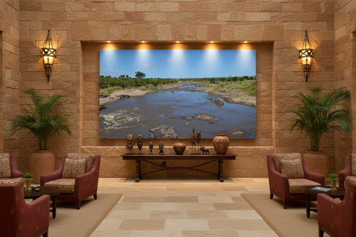 Before the Crossing — Mara River fine art print displayed in a grand luxury hotel lobby with warm stone walls and African-inspired decor — Wild East Visuals