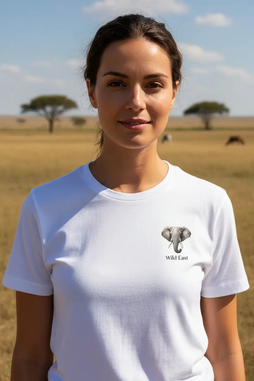 Woman wearing Wild East White Tee in the African savannah with acacia trees and open plains — Wild East Visuals