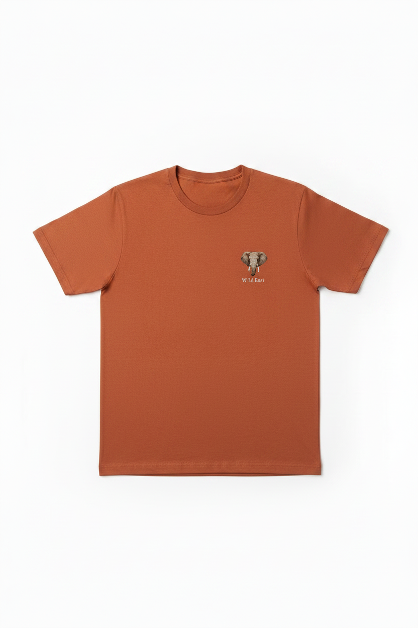 Wild East Terracotta Tee flat lay — elephant badge on left chest, 100% cotton, Wild East Visuals